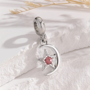 Macro view of silver star and moon charm with pink stone for DIY bracelet and necklace