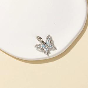 Pastoral style silver butterfly pendant with colorful crystals and enamel on a white stand