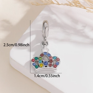 Macro shot of silver crown charm with multicolored rhinestones and detailed size marking