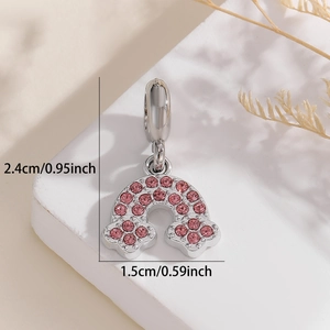 Close-up of pink crystal rainbow charm with silver cloud details and size markings