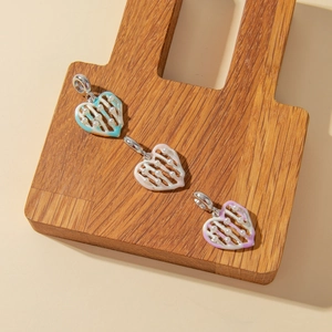 Macro detail of heart-shaped pendants with white pearls and colorful enamel work