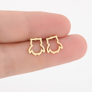 Nahaufnahme minimalistischer goldener Eulenohrringe im Hohldesign auf Fingerspitzen
