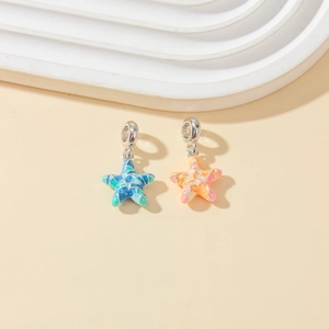 Macro shot of colorful star-shaped mosaic charms with silver clasps for DIY jewelry