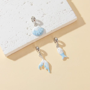 Detailed macro view of marine blue enamel shell, fish and fishtail DIY jewelry charms