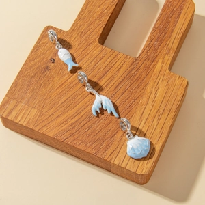 Detailed view of silver marine charms with blue enamel fish tail and shell for DIY jewelry