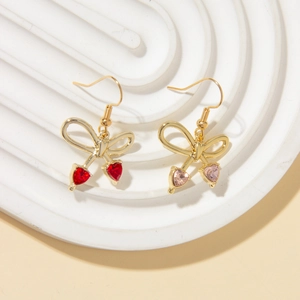 Detailed close-up of bow knot heart drop earrings in ruby red and light pink crystals