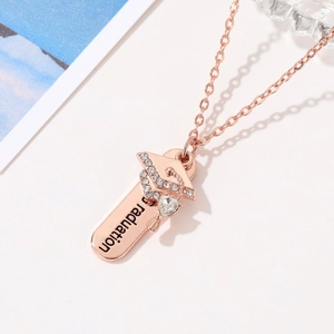 Detailopname van roségouden afstudeerketting met doctoraatshoedje en zirkoonhartje