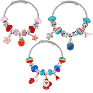 Dettaglio di braccialetti natalizi con perline in temi rosa e blu e ciondoli festivi