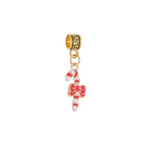 Détail d'un pendentif de canne de Noël dorée avec un nœud rouge et finition émail