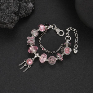Primo piano di un braccialetto rosa con ciondolo acchiappasogni e perle di cristallo