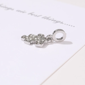Detailed view of puzzle piece charm with clear rhinestones for DIY necklaces