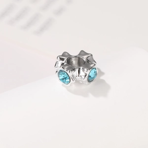 Petal-shaped silver charm with blue crystals and central hole for DIY jewelry making