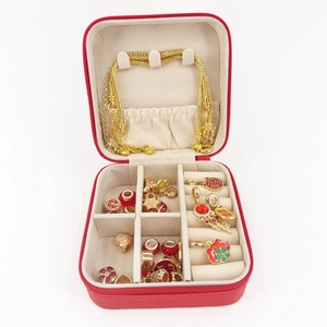 Portable red faux leather jewelry box with zipper and gold necklaces storage layout