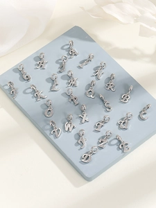 Detailansicht der silbernen Buchstaben-Anhänger A-Z mit weißem Zirkon-Inlay auf blau