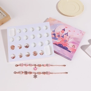 Detail van doe-het-zelf adventskalender armbandset in roségoud met feestelijke bedeltjes
