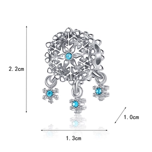 Macro shot of silver snowflake charm with blue stones and detailed size measurements