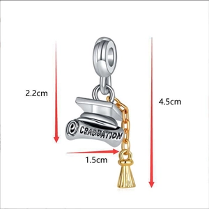 Macro detail of silver graduation cap charm with gold tassel and graduation engraving