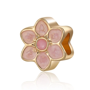 Detailed view of a gold-toned flower bead with pink glitter petals for DIY jewelry