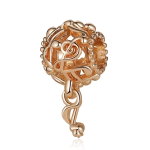 Gros plan d'une breloque note de musique en or rose avec clé de sol pour bracelets DIY