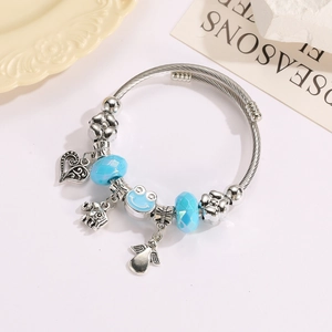 Beaded charm bracelet with silver spiral wire, blue faceted beads and elephant pendant