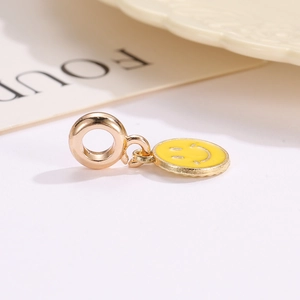 Detailed view of a golden yellow enamel smiley face charm for DIY jewelry and necklaces