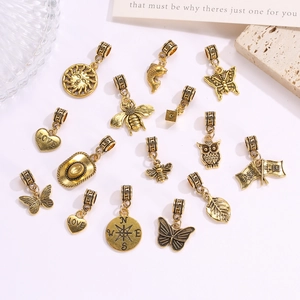 Close-up van vintage goudkleurige bedeltjes met vlinder- en bijmotieven en gravures