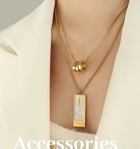 Double-layered gold necklace featuring three-ring charm and a white shell pendant insert