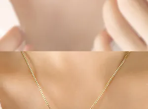 Close-up of a golden box chain necklace with elegant square links on a model's neck