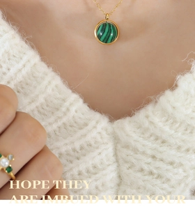 Vue détaillée d'un collier doré avec un pendentif rond rotatif en pierre de malachite