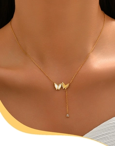 Nahaufnahme der goldenen Doppel-Schmetterling-Kette mit Perlmutt und Zirkonia-Tropfen