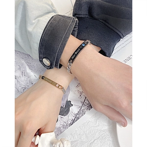 Détail des bracelets de couple en acier titane avec gravures Her Beast et His Beauty