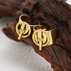 Anillos abiertos de acero inoxidable dorado con cierre OT sobre base de madera
