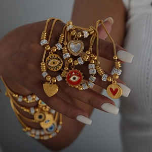 Vintage Titanstahl Armband Gold mit bösem Blick und Herzanhängern für Damen