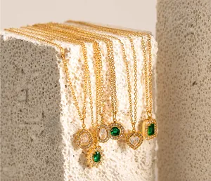 Dettaglio di collane con pendenti dorati e zirconi cubici trasparenti e verde smeraldo
