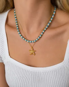 Detail of bohemian layered necklace with golden starfish pendant and turquoise beads
