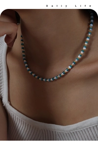 Nahaufnahme einer handgefertigten Perlenkette mit tiefblauen Natursteinen und Gold-Titan