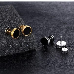 Detalle de los pendientes de acero de titanio dorado y plateado con incrustación de esmalte
