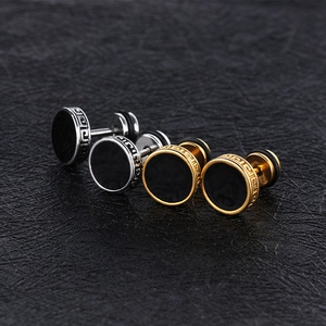 Primer plano de los pendientes de pesa con greca griega y detalle en negro metal