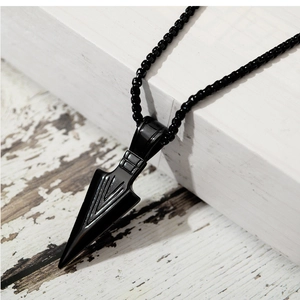 Macro view of black spearhead pendant necklace showing polished metallic finish and geometry