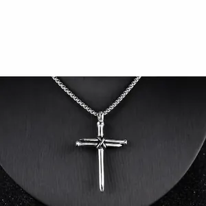 Detail of cross pendant made of three metal nails with a twisted industrial texture
