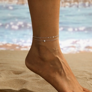 Bracelet de cheville double couche en acier titane de luxe avec zircon sur fond de plage