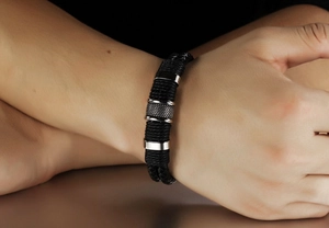 Primer plano de pulsera de cuero trenzado de doble capa con detalles de acero moleteado
