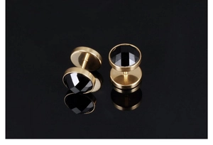 Macro detail of round gold titanium steel stud earring featuring a faceted black zircon stone