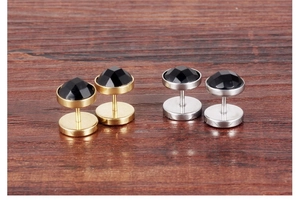 Detailed view of punk style round black crystal studs in gold and silver steel finish