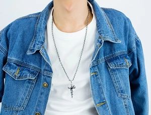 Retro punk style sword and dragon pendant necklace shown on male model wearing denim jacket