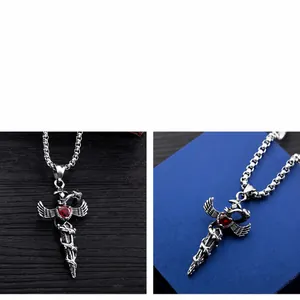 Detail of vintage snake and sword pendant with a red heart gem on a steel cross chain