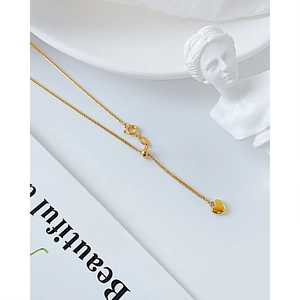 Elegante collar con colgante de corazón dorado y cadena ajustable en fondo limpio