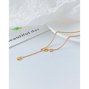 Detalle de collar con colgante de corazón dorado con cadena ajustable y cierre de anillo