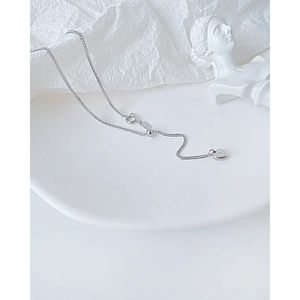 Detalle del collar con colgante de corazón plateado con cuenta ajustable y cierre