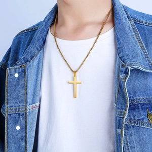 Klassische goldene Edelstahl-Kreuz-Halskette getragen von einem männlichen Model über T-Shirt